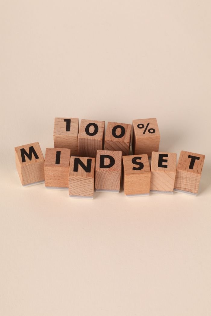 Wooden blocks spelling '100% MINDSET' symbolizing motivation and positive thinking.