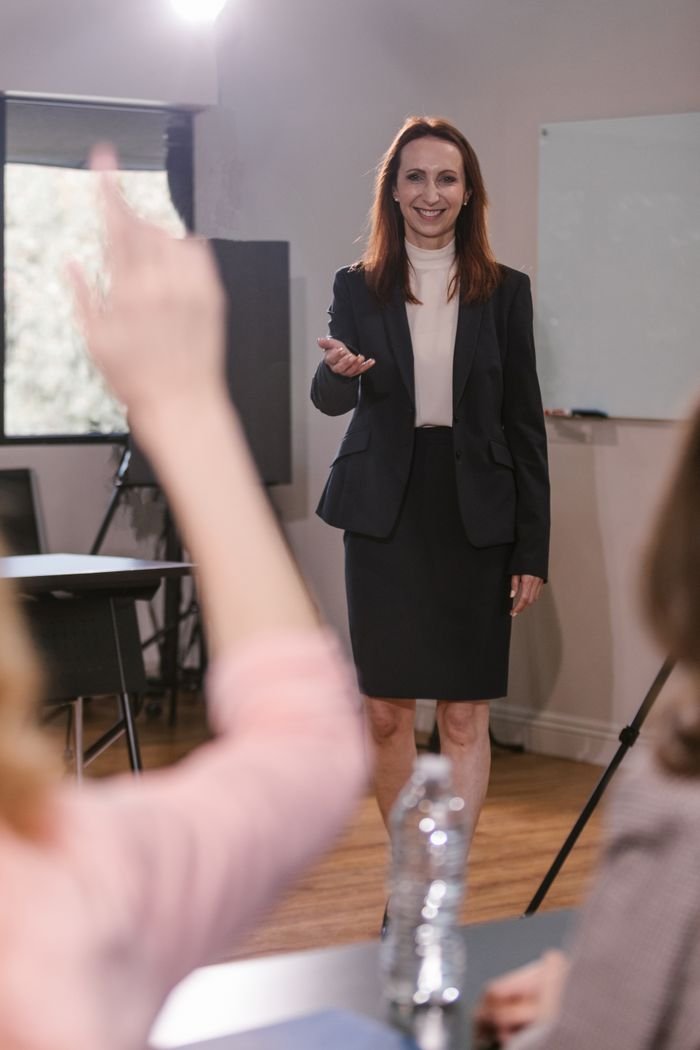 Confident businesswoman speaking to a team during a meeting indoors.